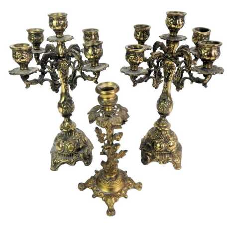 A pair of 20thC four branch candelabra, each cast with scrolls, etc., 32cm high, together with a single brass candlestick cast with acorns, leaves, etc., on four paw feet, 22cm high.