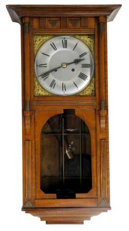 An early 20thC mahogany cased wall clock, the arched top with reeded columns and brass inlay, with a brass floral back, silvered dial, Roman numeric panel, 62cm high, 30cm wide, 14cm deep.(AF)