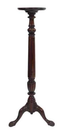 A 20thC mahogany torchere, the circular dish top raised on a part reeded and fluted carved column, raised on three leaf carved cabriole legs with ball and claw feet, 136cm high.