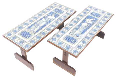 A pair of 20thC tile top and oak coffee tables, decorated with female figure within a floral border, on shaped end supports united by stretcher, 39cm high, the top 85cm x 45cm.