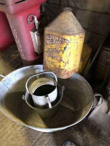 A galvanised bath, cans and two lubricant tins.