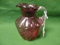 A cranberry glass jug of lobed form