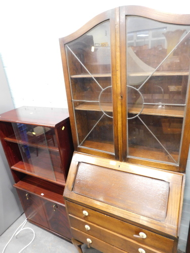 An oak bureau bookcase, in the Art Deco style, the top with astragal glazed doors and arched top, above fall flap and three drawers, on pad feet, and a reproduction bookcase. (2)