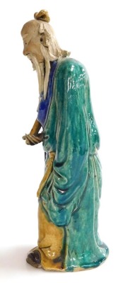 A 19th/20thC Chinese part glazed ceramic figure of a sage, in green, blue and yellow; holding a sheathed sword, 31cm high. - 2