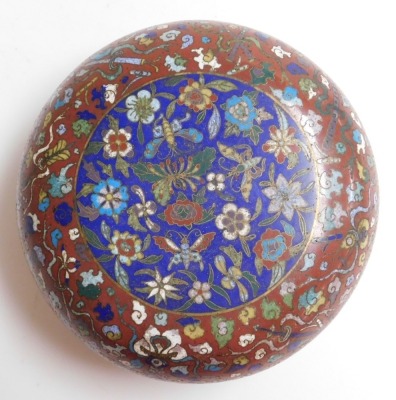 A 19thC Chinese circular compressed cloisonne enamel box, decorated with emblems of flowers and precious objects, on a red ground, the cover with central panel of butterflies and flower heads in polychrome enamels, on blue ground, 11cm high, 24cm diameter - 5