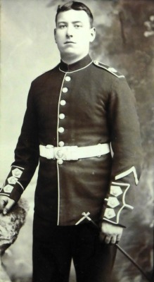 Early 20thC silk needlework panel with WW1 flags of the Allies. Black and white portrait photograph of a guardsman and inscribed "In the memory of my cruise in China and Japan, on black backing with England expects...in text to the lower border, 44cm x 39 - 3