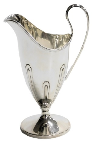 A George V silver cream jug, of helmet form, with a scroll handle, and embossed decoration, Barker Brothers Silver Limited, Birmingham 1929, 4.93oz.