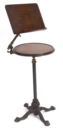 A Victorian walnut, oak and cast iron music stand, by Leveson & Sons, London, the sheet music stand on a brass adjustable arm, above a circular table, raised on a straight column and four leaf capped lion's paw feet, 112cm high.