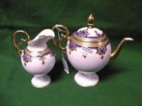 A Limoges porcelain small teapot and cream jug each with blue bands and