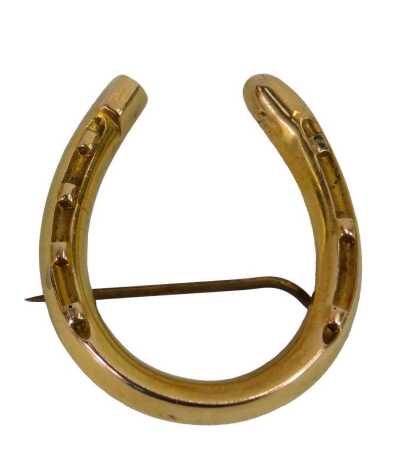 A 9ct gold horseshoe shaped brooch, on a single pin back, 2.5cm wide, 2.9g all in.