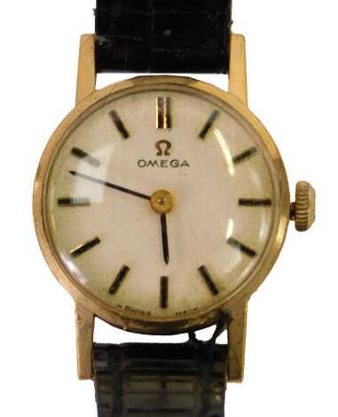 An Omega 9ct gold cased lady's wristwatch, with a silvered batoned dial and black hands, on a black leather strap, the dial 1cm diameter, 10.8g all in, boxed.