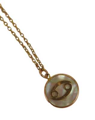 A mother of pearl pendant and chain, the circular mother of pearl with raised yellow metal detail, 1.5cm wide, on a fine link neck chain with barrel clasp, stamped 9ct, 40cm long, 4g.