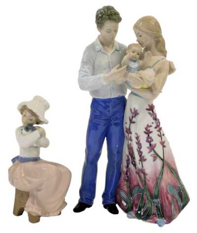 An Old Tupton ware porcelain figure group, modelled as Mother, Father and Child, item No. TW1110LE, limited edition No. 71/300, 29cm high, boxed with a certificate, together with a Nao porcelain figure modelled as a girl seated holding a puppy, 18cm high,