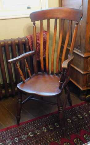 A lath back Grandfather chair, with a solid seat, on turned legs with H stretcher. This lot is located offsite. For further details and to arrange a viewing, please call The Bourne Auction Rooms on 01778 422686.