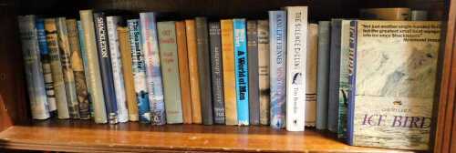 A group of Antarctic and snow adventure books and reference guides, including Polar Aviation, Shackleton, Big Dead Place, 90 Degrees South, The World of Men, etc. (1 shelf)