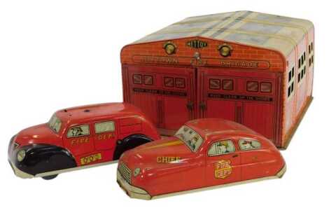 A Mettoy Joytown Fire Brigade tinplate building, 11cm high, together with two Fire Department vehicles. (3)