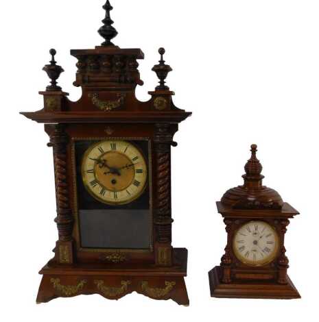 A late 19th/early 20thC mahogany cased mantel clock, the brass circular dial with cream enamel chapter ring bearing Roman numerals, thirty hour, the case with turned finials to top, turned pilasters, with brass decoration, bows, swag and rosettes, 61cm hi