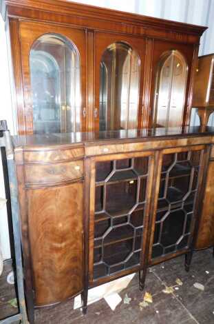 A mahogany bow front display cabinet, with two pillared column cupboards, two astragal glazed centre doors, and an associated display cabinet. (2)