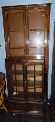 An oak bookcase, with two glazed doors enclosing an arrangement of shelves, together with an open bookcase, and another.