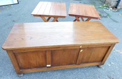 An oak blanket chest, three panelled front, 46cm high, 101cm wide, 40cm deep, together with two folding tables, each with a slatted top.