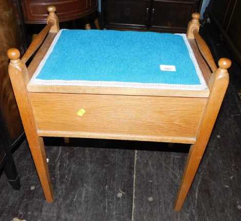 An oak piano stool, with teal upholstered top, 61cm high.