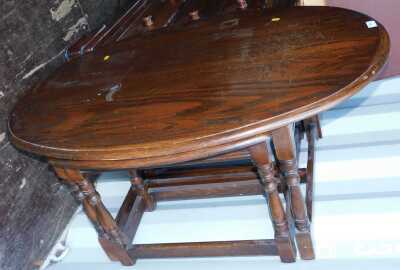 An oak nest of two tables, the oval top raised on turned legs united by stretchers, the largest 45cm high.