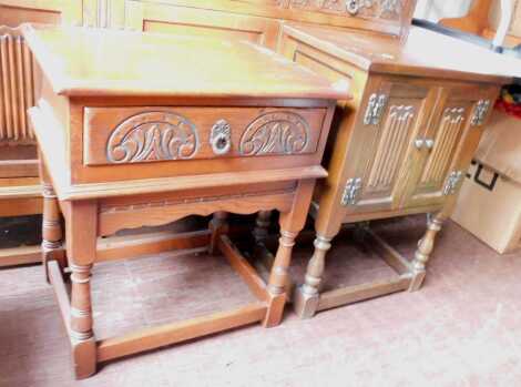 An oak Old Charm side cabinet, with carved doors, on turned legs united by stretchers, 71cm high, together with an oak side table, with frieze drawer. (2)