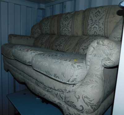 A three seater sofa, upholstered in foliate fabric. 
The upholstery in this lot does not comply with the 1988 (Fire & Fire Furnishing) Regulations, unless sold to a known exporter or upholsterer it will be cut from the frame before leaving the premises.