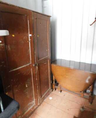 A painted pine cabinet, with two panelled doors, enclosing various shelves, 177cm high, 114cm wide, 43cm deep, together with an oak drop leaf table.