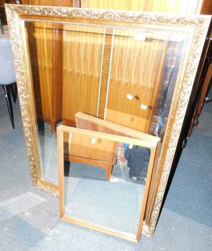 A rectangular gilt framed wall mirror, decorated with scrolling leaves, 113cm x 86cm, together with a leaf framed wall mirror. (2)