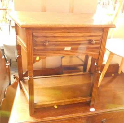 A 20thC oak side table, shaped top above a frieze drawer with under tier, 72cm high, 70cm wide, 39cm deep.