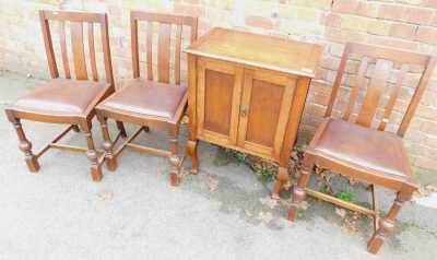 An oak cabinet with two panelled doors, on cabriole legs, 79cm high, together with three oak dining chairs, each with a drop-in red leatherette seat. (4)