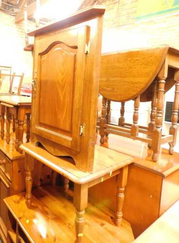 A pine nest of three tables, the largest 43cm high, the top 89cm x 41cm, together with a pine coffee table, and an oak corner cabinet.