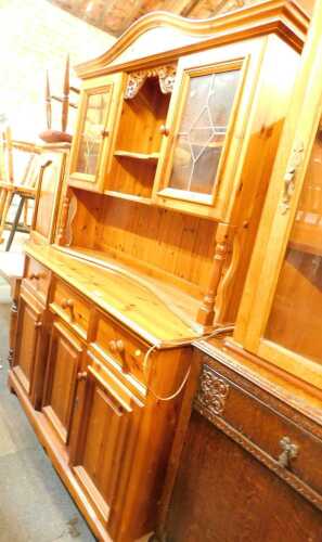 A pine dresser, the top with two shelves flanked by two leaded glazed cabinets, the base with three drawers above three cupboards, on bracket feet, 193cm high, 134cm wide, 47cm deep.