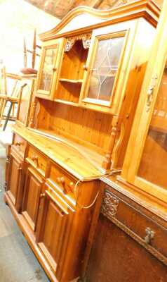 A pine dresser, the top with two shelves flanked by two leaded glazed cabinets, the base with three drawers above three cupboards, on bracket feet, 193cm high, 134cm wide, 47cm deep.