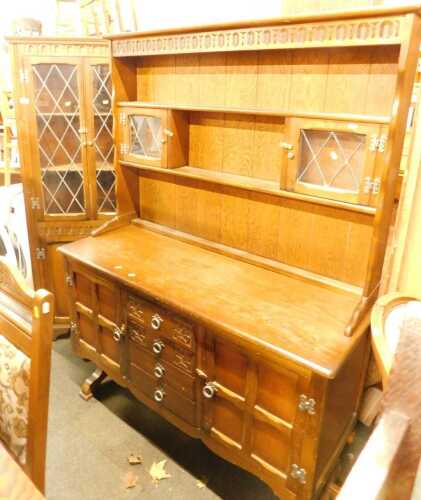 An oak dresser, 169cm high, 128cm wide, 48cm deep, together with a matching standing corner cabinet.