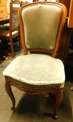 An oak bedroom chair, in French style, with turquoise overstuffed seat and back, on cabriole legs with scrolling feet. The upholstery in this lot does not comply with the 1988 (Fire & Fire Furnishing) Regulations, unless sold to a known exporter or uphols