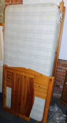 A pine framed bunk bed, comprising head, foot, base and two mattresses.