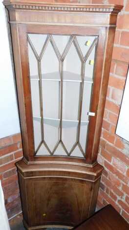 A mahogany standing corner cabinet, with astragal glazed concave door and cupboard to base, 180cm high.