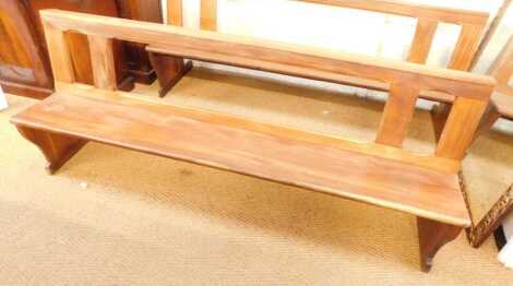 A 20thC hardwood pew, with a pierced back and solid seat, 213cm long.