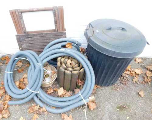 A black plastic bin, a section of wooden post fencing, together with a pottery birdbath, a wooden folding table, etc.