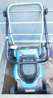 A Makita electric lawn mower, lacking grass collecting box.