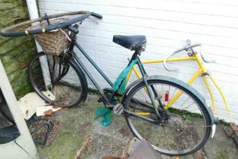 An Elswick vintage bicycle, in green trim with wicker basket, together with a spare wheel, and a bicycle frame in yellow trim.