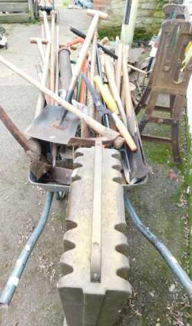 A wheelbarrow containing various garden tools, together with an Aladdin greenhouse heater.