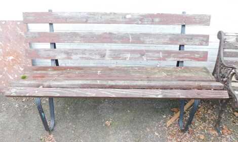 A garden bench, with wooden slatted seat and back, on wrought iron supports, 160cm wide.