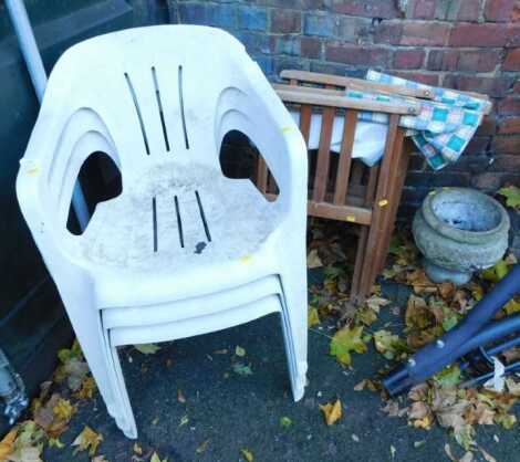 Three white plastic garden chairs, two director's type folding chairs, and a composition stone planter.