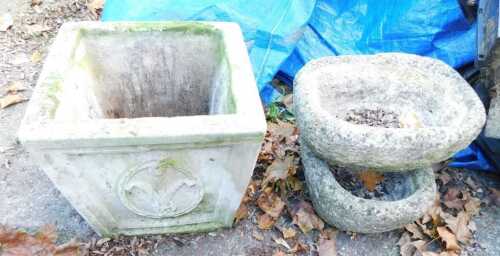 A composition stone garden planter, of square tapering form, decorated with Prince of Wales feather, 32cm high, together with two composition stone planters, of oval form. (3)