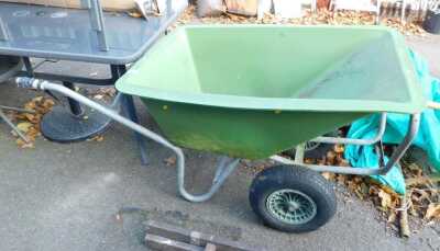 A green plastic wheelbarrow.