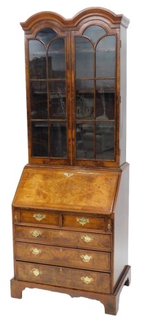 A Queen Anne style figured walnut bureau bookcase, with a double dome top over two astragal glazed doors, the fall flap resting on lopers revealing a fitted interior, over two short and three long graduated drawers, with brass solid plate engraved loop ha