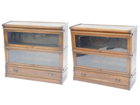 A pair of Globe Wernicke bookcases, both with shaped top, two glazed doors over single drawer base, 78cm high, 87cm wide.